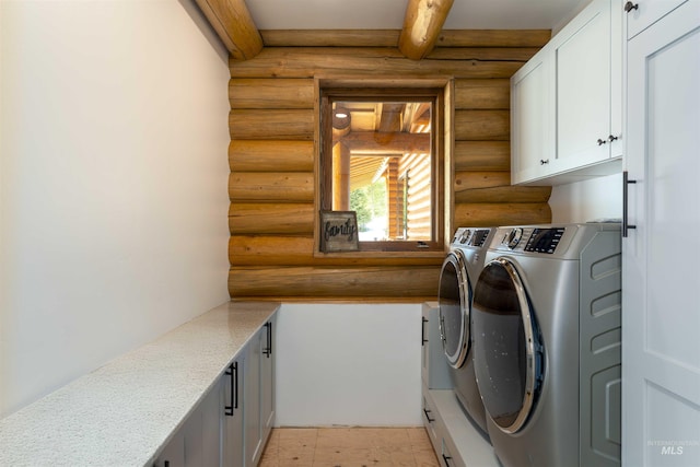 clothes washing area with washing machine and dryer, rustic walls, and cabinet space