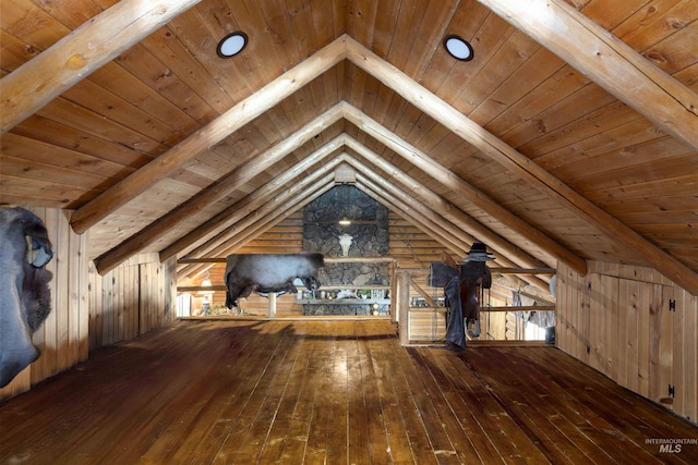 interior space with wood ceiling, wood walls, hardwood / wood-style floors, and vaulted ceiling with beams
