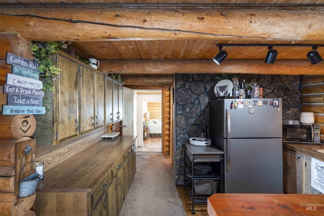 kitchen with freestanding refrigerator, log walls, and wooden ceiling