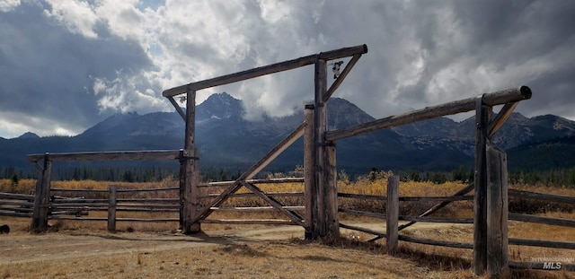 view of gate with fence and a mountain view