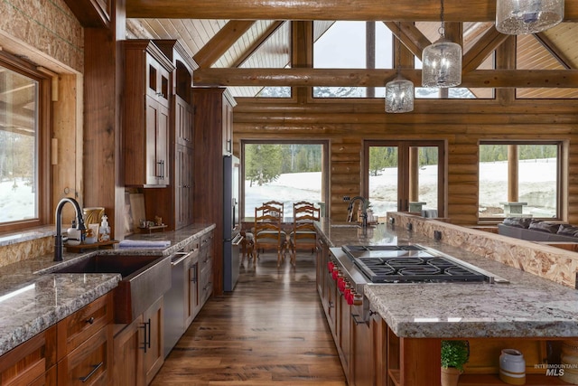 kitchen featuring rustic walls, beam ceiling, a sink, and plenty of natural light