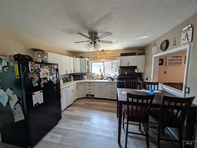 116 Main St, Stites, ID 83552 - kitchen with ceiling fan, a sink, wood finished floors, under cabinet range hood, and black appliances