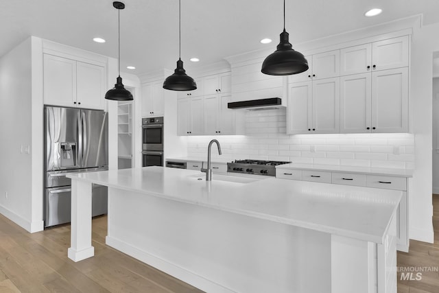 kitchen featuring appliances with stainless steel finishes, a sink, baseboards, light wood-type flooring, and recessed lighting