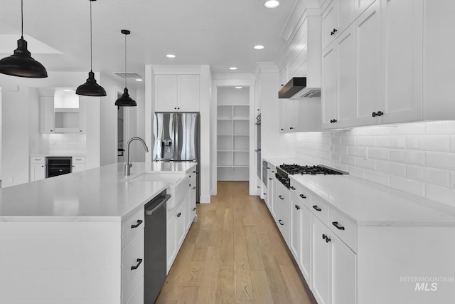 kitchen with a sink, recessed lighting, gas stovetop, light countertops, and wine cooler