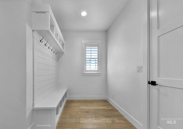 mudroom featuring light wood-style flooring, baseboards, a textured ceiling, and recessed lighting