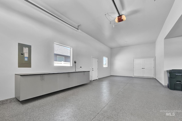garage featuring electric panel and a garage door opener
