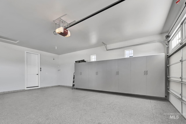 garage with a garage door opener and baseboards