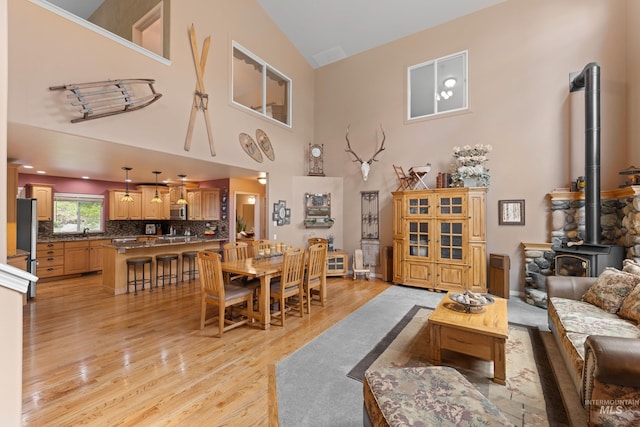 1611 Woodhaven Ln, Mccall, ID 83638 - living room featuring light wood-style flooring, a wood stove, and high vaulted ceiling