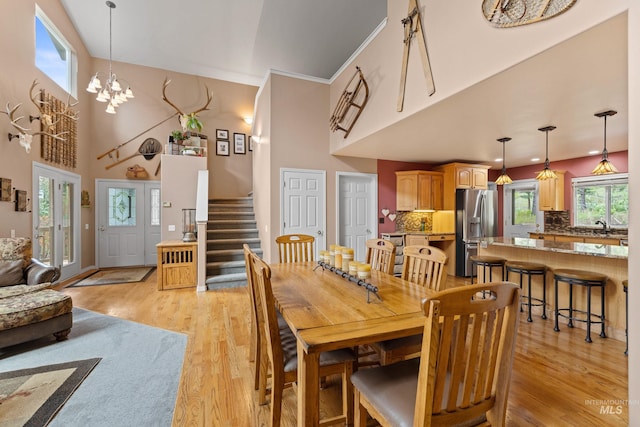 1611 Woodhaven Ln, Mccall, ID 83638 - dining room with light wood-style flooring, stairs, a towering ceiling, and a chandelier