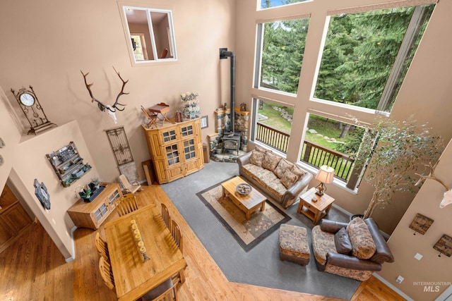 1611 Woodhaven Ln, Mccall, ID 83638 - living room featuring a wood stove, a high ceiling, wood finished floors, and baseboards
