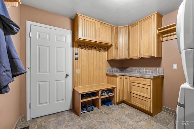 1611 Woodhaven Ln, Mccall, ID 83638 - mudroom featuring stacked washing machine and dryer, baseboards, and light stone finish flooring