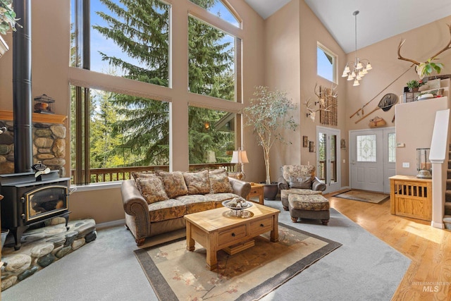 1611 Woodhaven Ln, Mccall, ID 83638 - living area with a wood stove, high vaulted ceiling, wood finished floors, and a chandelier