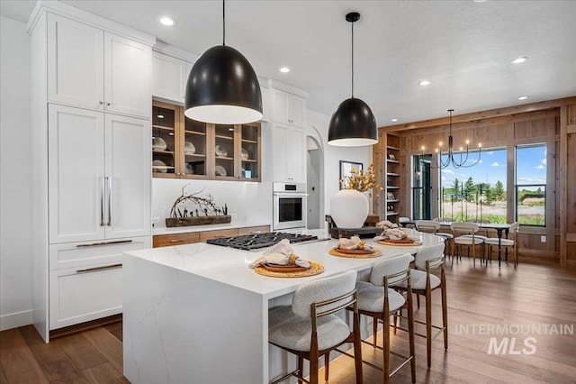 461 Centry Ave, Middleton, ID 83644 - kitchen with stainless steel appliances, white cabinets, dark wood finished floors, recessed lighting, and a center island