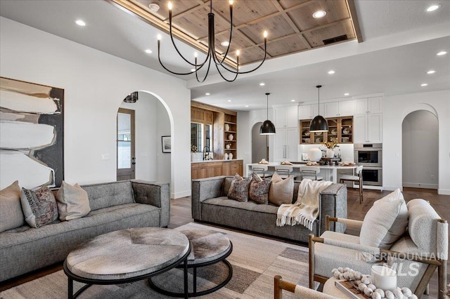 461 Centry Ave, Middleton, ID 83644 - living room with arched walkways, recessed lighting, coffered ceiling, a chandelier, and built in features