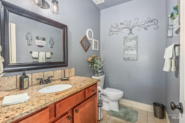 bathroom featuring tile patterned flooring, baseboards, vanity, and toilet