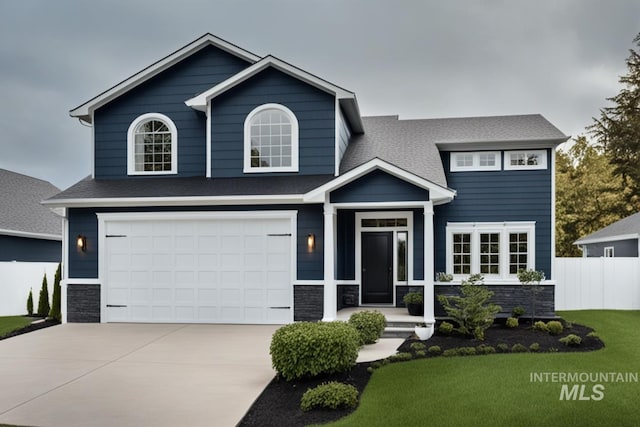 view of front of property featuring a garage, a shingled roof, concrete driveway, stone siding, and fence