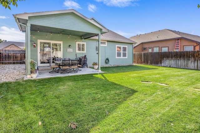 rear view of property with a patio, a yard, and a fenced backyard