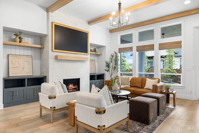 living area featuring an inviting chandelier, a stone fireplace, beam ceiling, and light wood-style floors