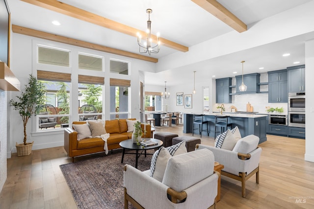 living room featuring an inviting chandelier, recessed lighting, light wood finished floors, and beamed ceiling