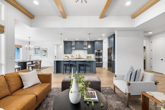 living area featuring recessed lighting, light wood finished floors, beam ceiling, and a notable chandelier