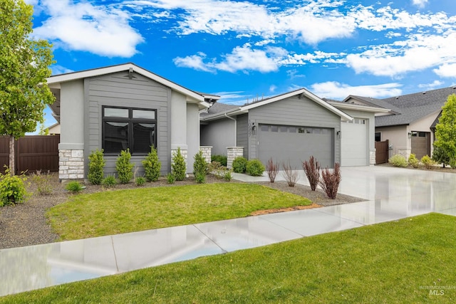 ranch-style house featuring a front lawn, fence, stone siding, concrete driveway, and an attached garage
