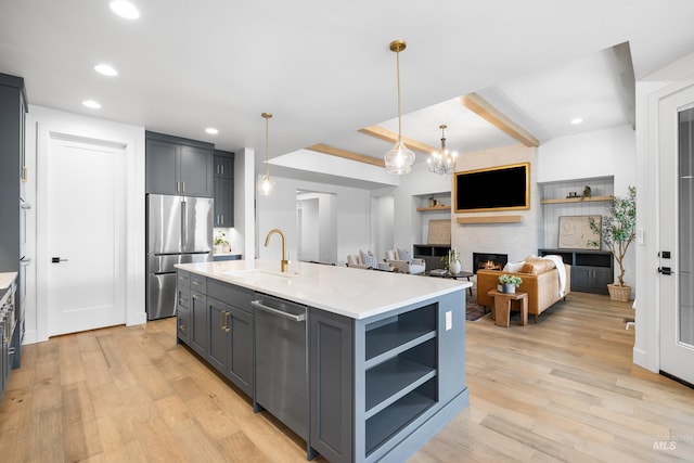 kitchen featuring light wood-style floors, light countertops, a sink, gray cabinetry, and stainless steel appliances