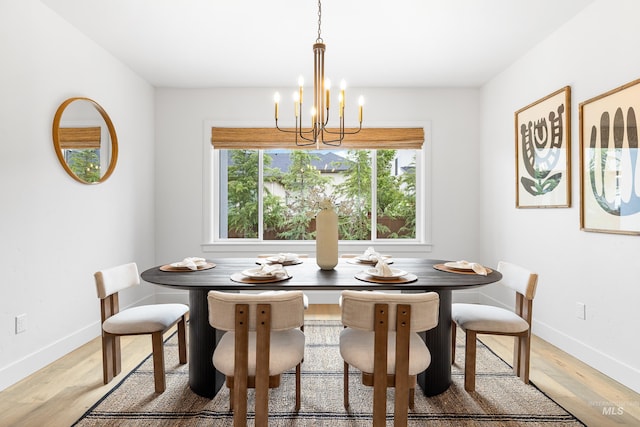 dining area featuring baseboards, a chandelier, and light wood-style flooring