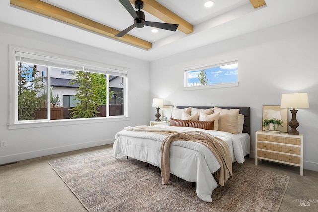 carpeted bedroom featuring visible vents, baseboards, multiple windows, and beamed ceiling