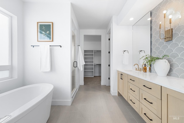 bathroom with vanity, recessed lighting, baseboards, a shower stall, and a soaking tub