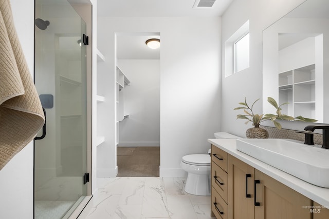 bathroom featuring vanity, toilet, marble finish floor, baseboards, and a stall shower