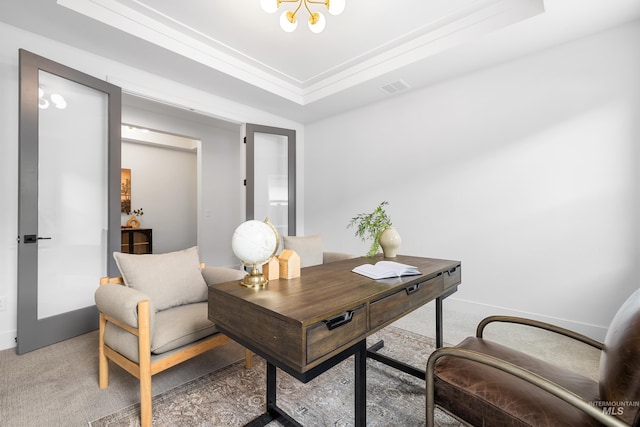 office featuring light colored carpet, visible vents, baseboards, a notable chandelier, and a tray ceiling