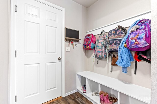mudroom with dark wood-style floors and baseboards