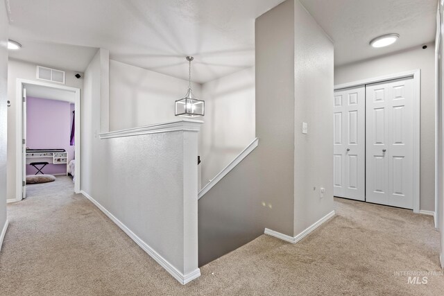corridor with carpet, an upstairs landing, and baseboards