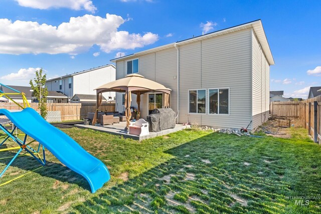 back of property with a playground, outdoor lounge area, a gazebo, and a patio area