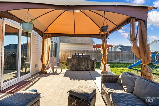 view of patio with a gazebo, an outdoor living space, and a fenced backyard