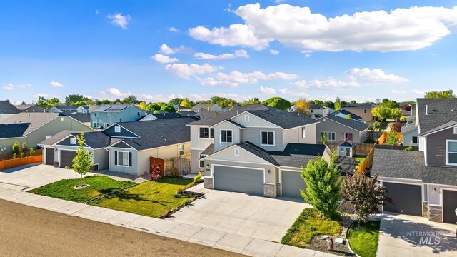 traditional home with a residential view, concrete driveway, and an attached garage
