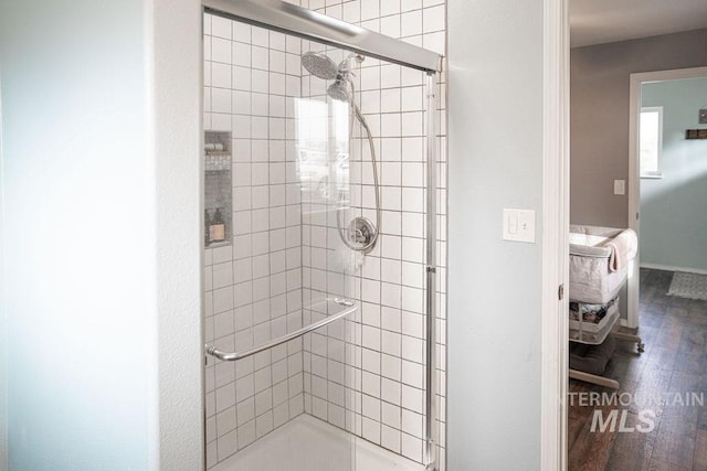 full bath with a shower stall and wood finished floors