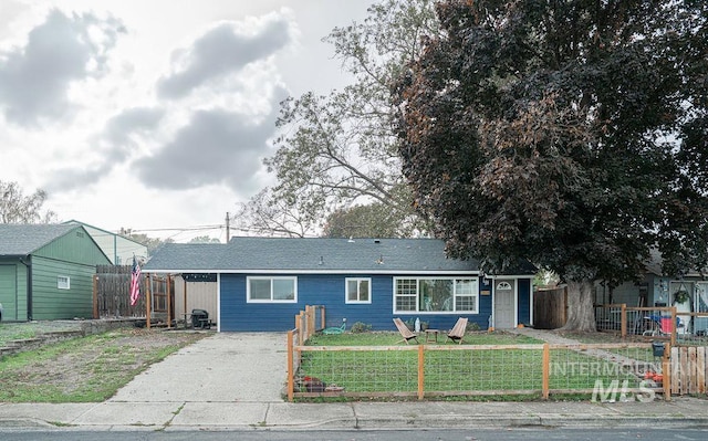 ranch-style home with a fenced front yard and a front lawn