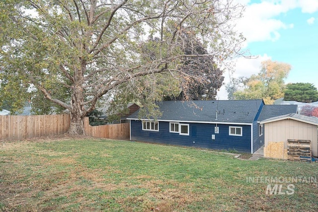 back of property with a yard and fence