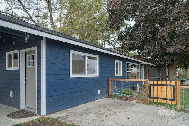 view of side of home with a patio and fence