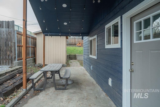 view of patio / terrace featuring an outbuilding and fence