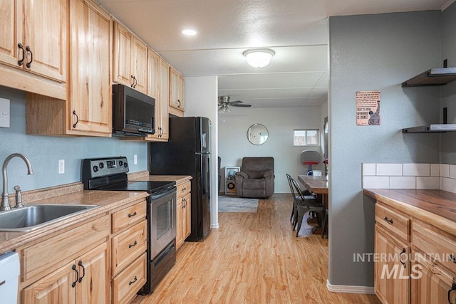 kitchen featuring black microwave, stainless steel electric stove, light wood-type flooring, a ceiling fan, and a sink