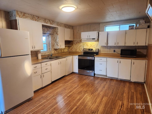 82 NW 3rd St, Ontario, OR 97914 - kitchen featuring freestanding refrigerator, stainless steel electric stove, black microwave, under cabinet range hood, and plenty of natural light