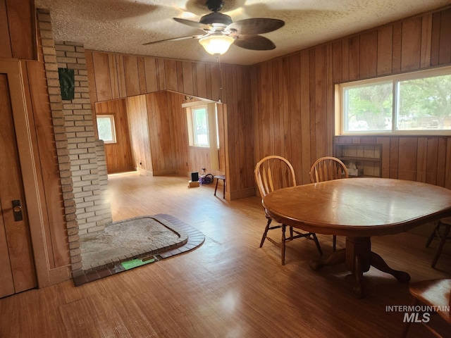 82 NW 3rd St, Ontario, OR 97914 - dining room featuring wooden walls, wood finished floors, a textured ceiling, and ceiling fan