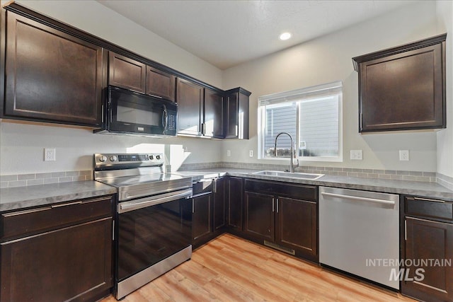 kitchen featuring stainless steel appliances, sink, dark brown cabinetry, and light hardwood / wood-style flooring