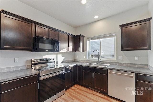 kitchen with sink, dark brown cabinets, light hardwood / wood-style floors, and appliances with stainless steel finishes