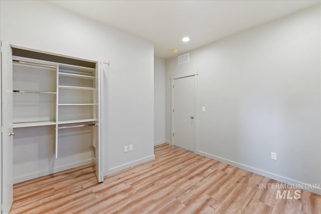 unfurnished bedroom featuring light hardwood / wood-style floors and a closet