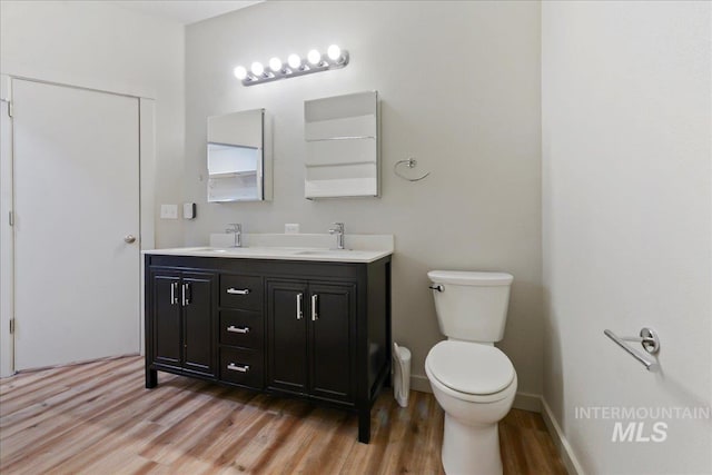 bathroom with vanity, hardwood / wood-style flooring, and toilet