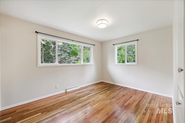 unfurnished room featuring light wood-style flooring and baseboards