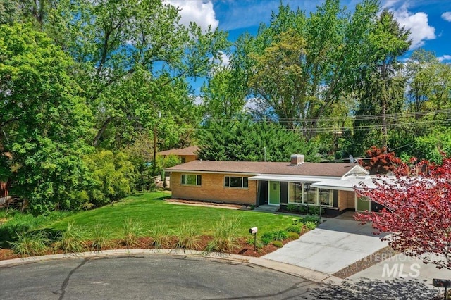 view of front of property featuring a front lawn and concrete driveway